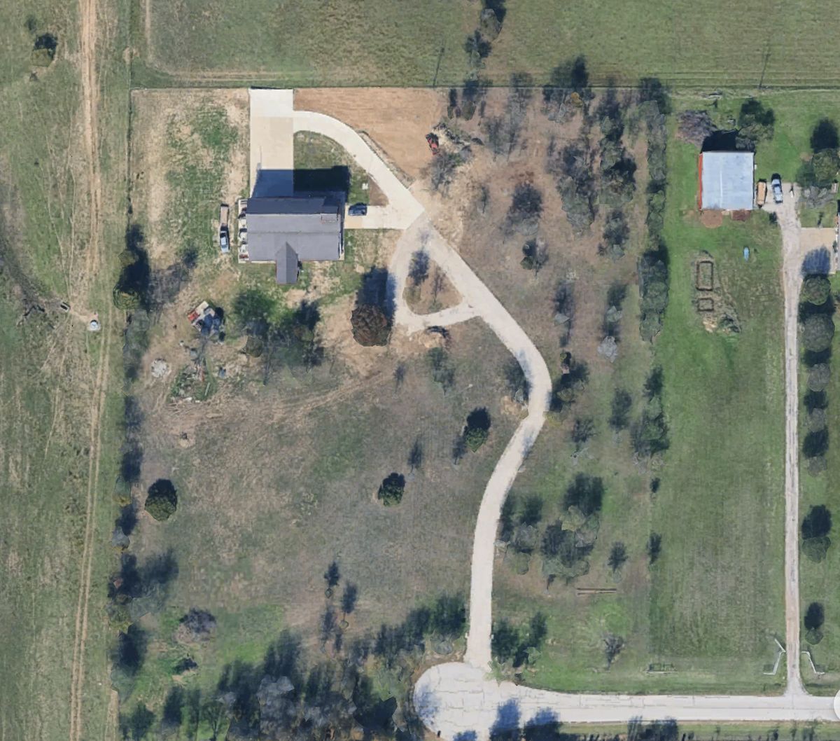 Aerial view of The Helo Station property: a private driveway winds from the cul-de-sac north through the trees to the hangar